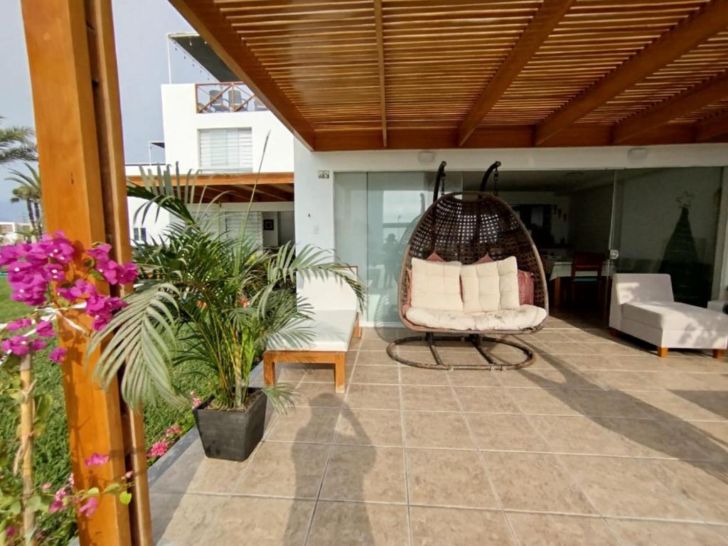 a porch with a chair and a swing at Espectacular Casa de Playa en Asia frente al Mar in Asia