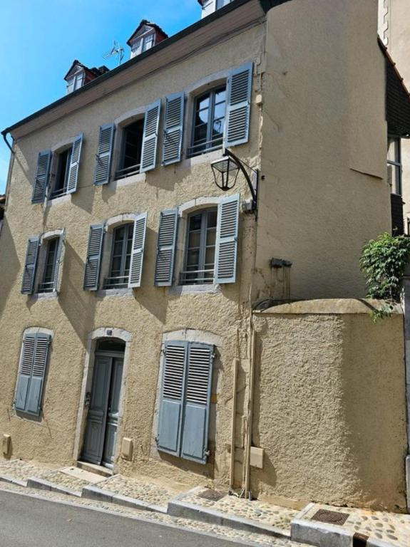 un bâtiment avec volets bleus sur son côté dans l'établissement Coeur Historique - CosyHome 18 - Parking à proximité, à Pau