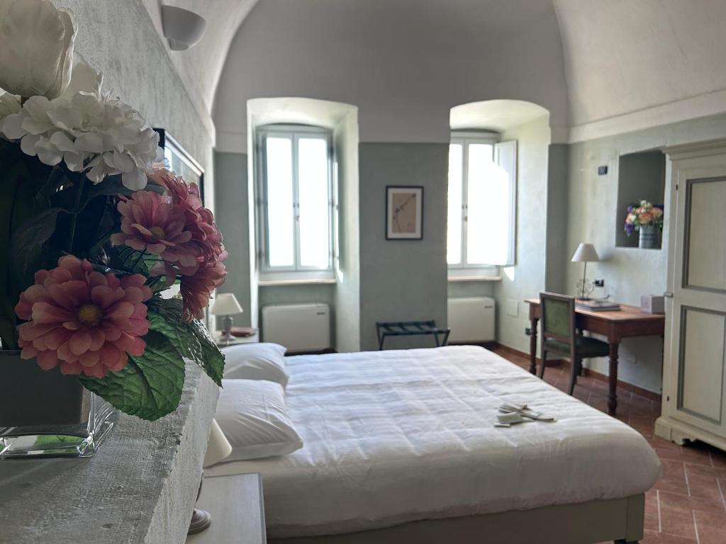 a bedroom with a bed with a vase of flowers at Palazzo Contelori in Terni