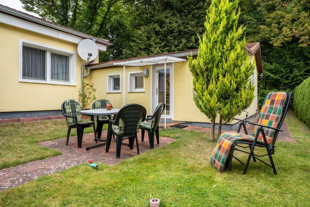 Un grupo de sillas y una mesa en un patio. en Prerow Am Deich - Ferienwohnung 4, en Prerow