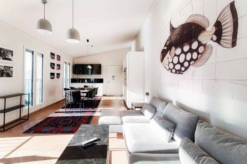 a living room with a couch and a table at Unique Gandria Attic by Quokka 360 - Elegant Lake View Apartment in Lugano