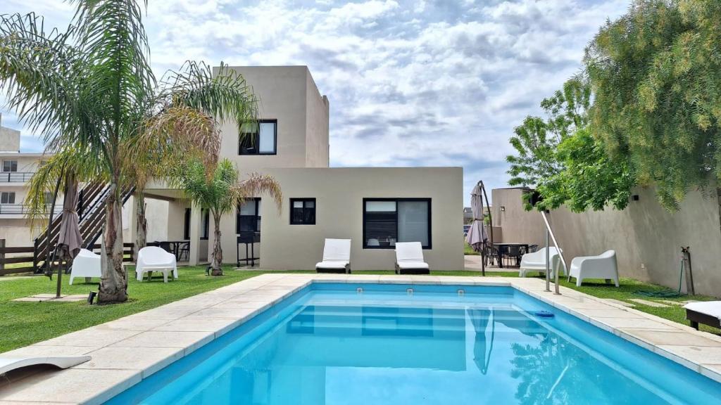 a swimming pool in front of a house at Maderos Apart in Federación