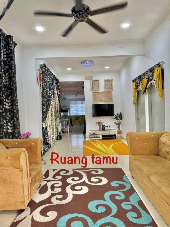 a living room with two couches and a ceiling fan at iLham Homestay in Kangar