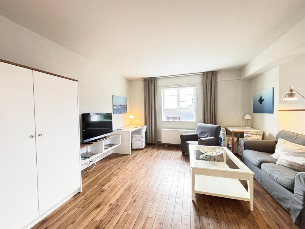 a living room with a couch and a tv at Pier 7 im Pierspeicher in Kappeln