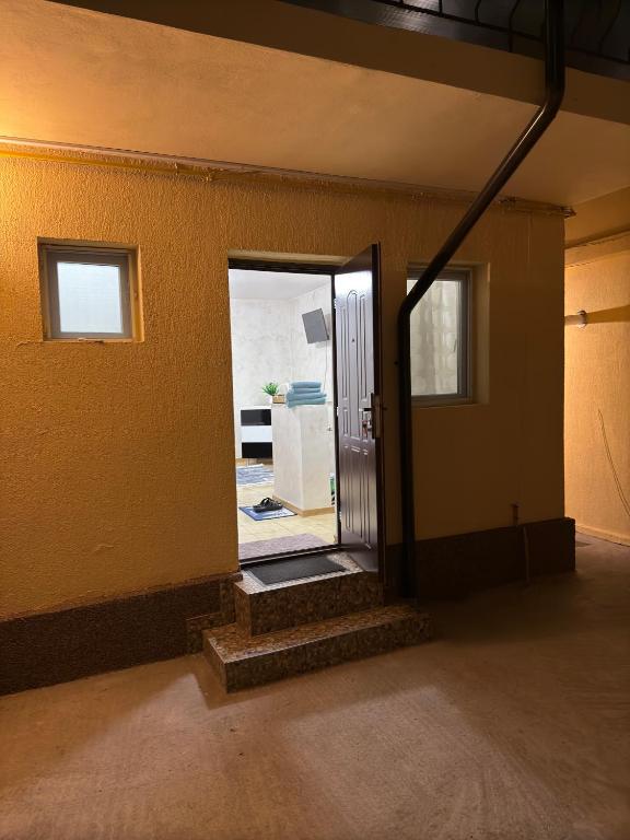 an empty room with a door open to a kitchen at Home Efrem in Bucharest