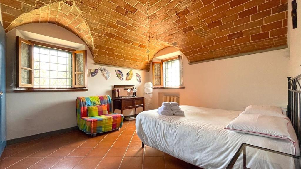 sypialnia z łóżkiem i krzesłem w obiekcie Brucina - Private holiday apartment with shared pool w mieście Montelupo Fiorentino