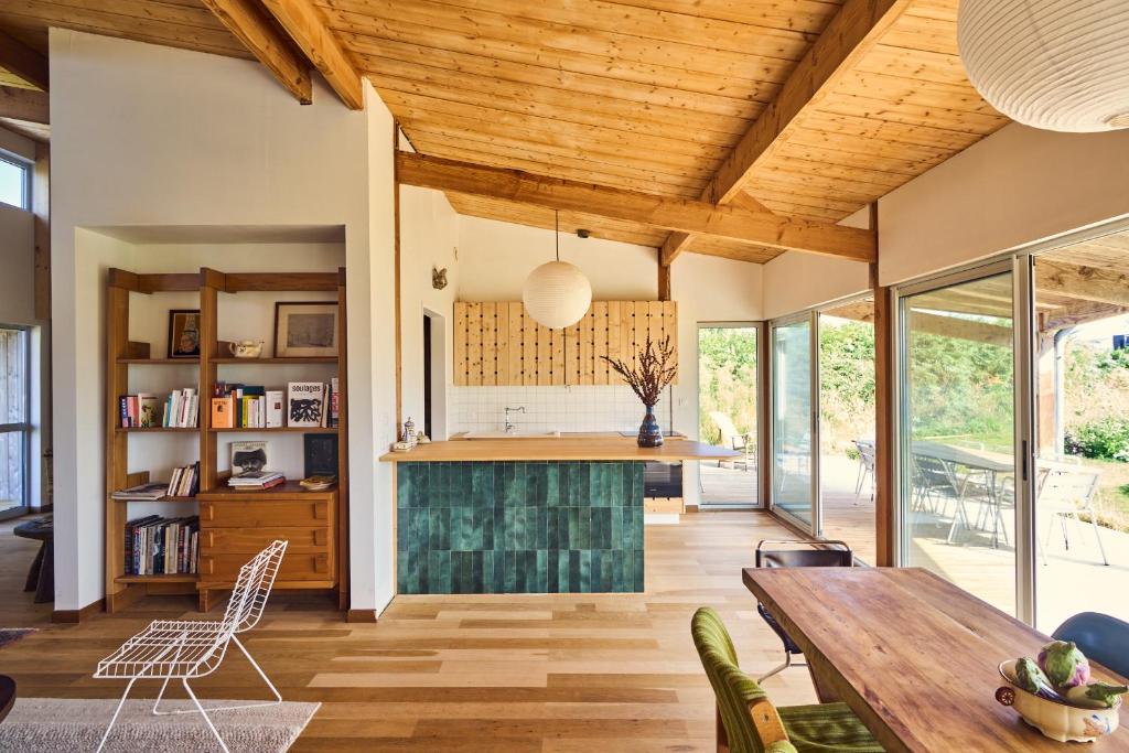 an open living room with a wooden ceiling at Maison moderne, ambiance californienne, proche mer in Plouescat