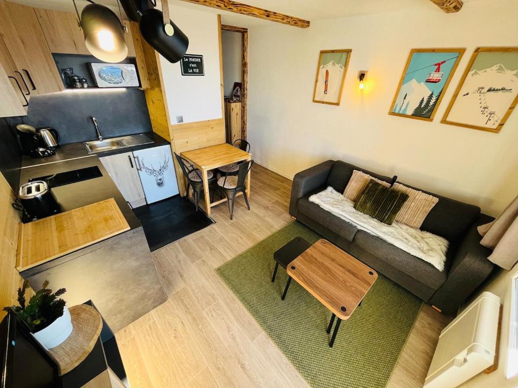 une vue aérienne d'un salon avec un canapé et une table dans l'établissement T2 4 personnes - Proche pistes, à Huez