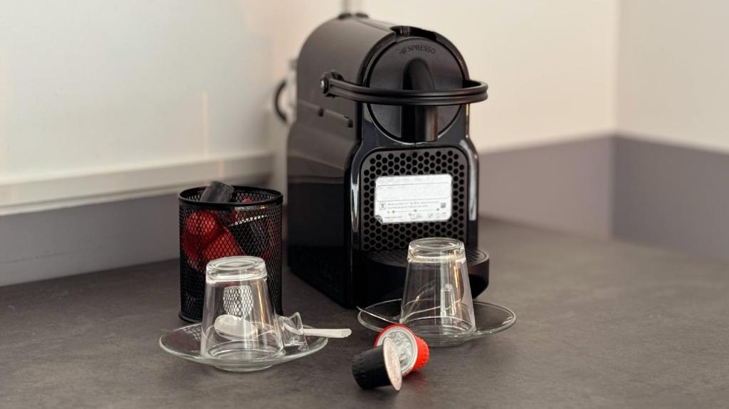 a black juicer with two glasses and a cup at My Tiny Home in Rome