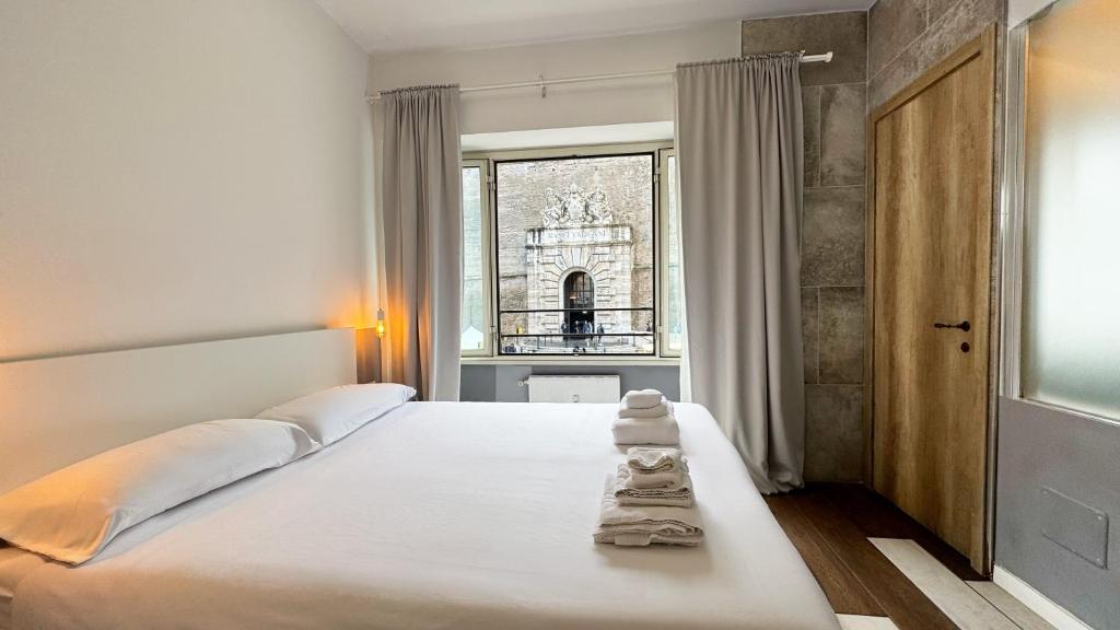 a bedroom with a large white bed with towels on it at My Tiny Home in Rome