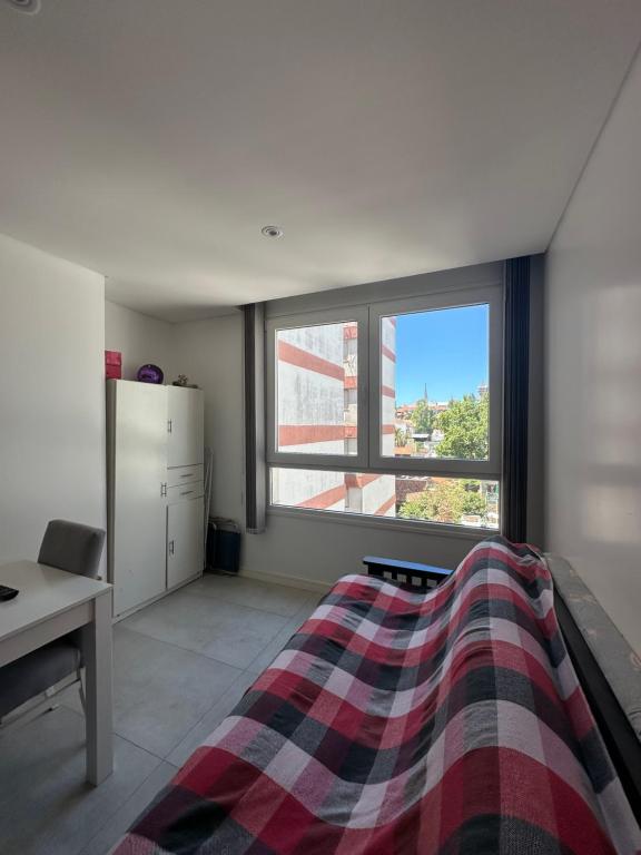 マル・デル・プラタにあるDepartamento con cochera zona Guemesのベッドと机と窓のある寝室