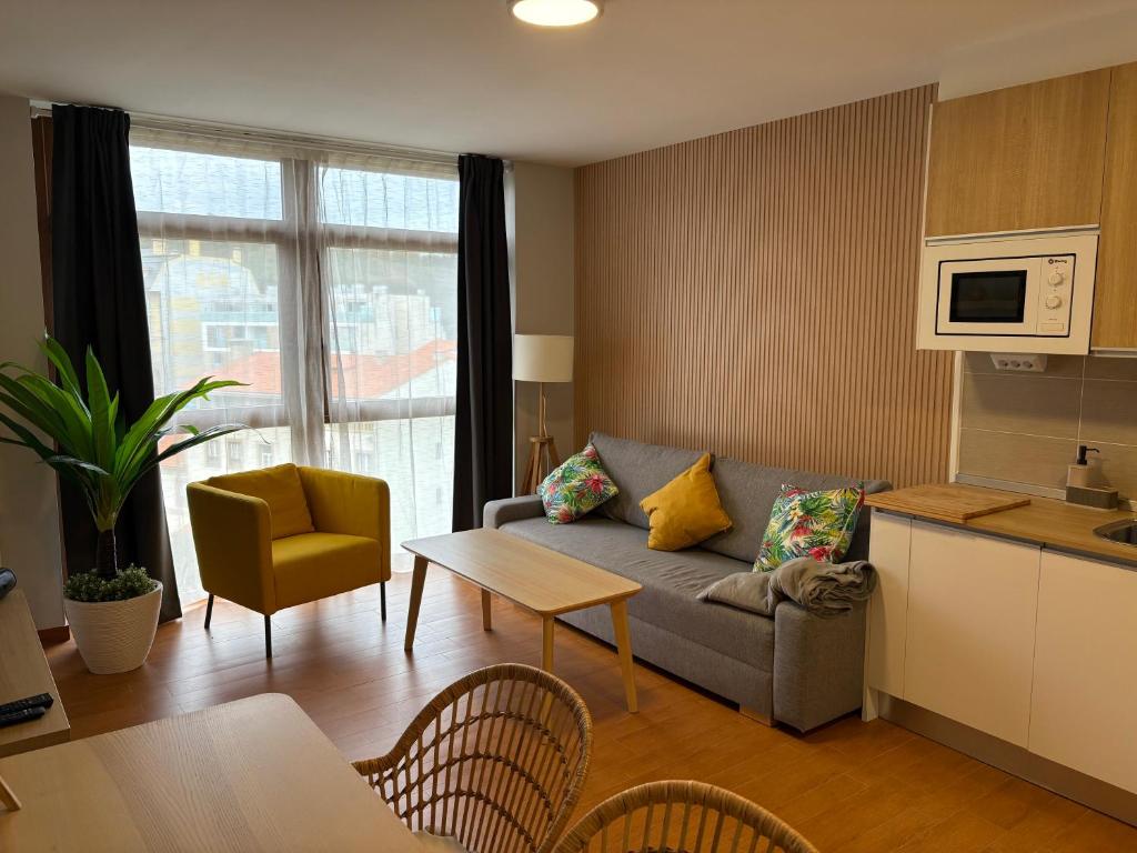 una sala de estar con un sofá y una mesa en Malpica Home, en Malpica de Bergantiños