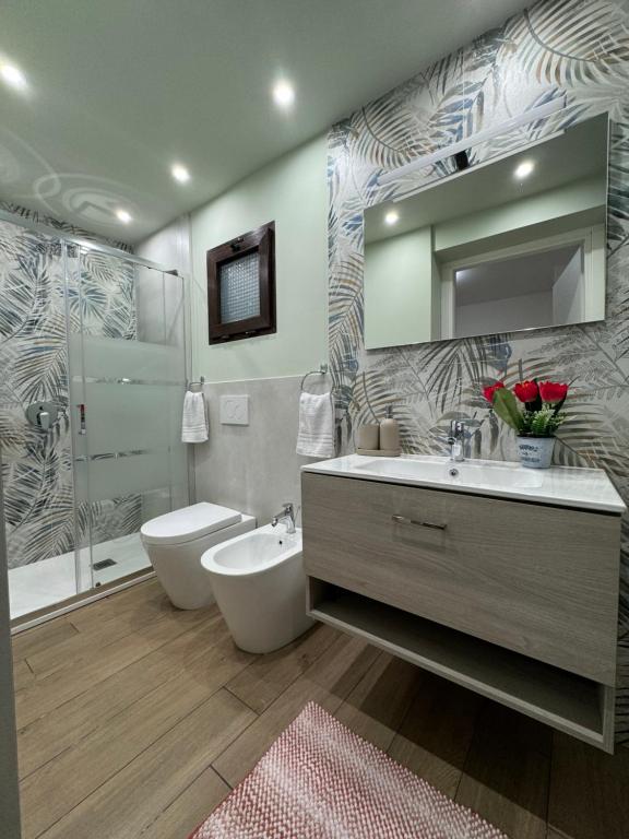 a bathroom with a sink and a toilet and a mirror at Il Tulipano house in Catania