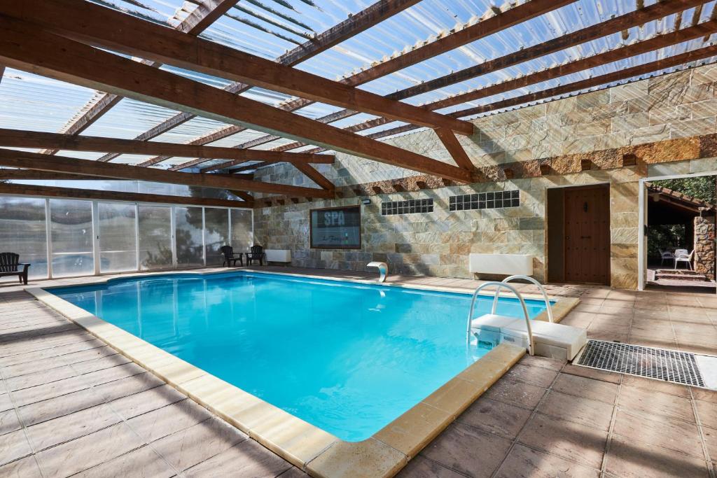 an indoor swimming pool with a wooden roof at Preciosa villa rural a poca distancia de Ávila by Alterhome in Velayos