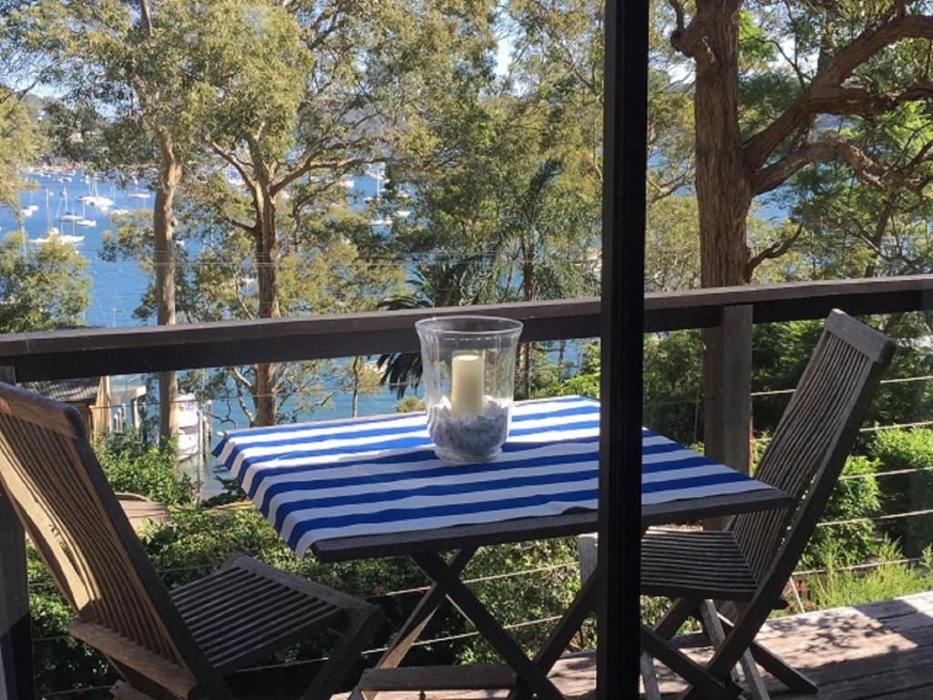 a table with a candle sitting on top of a deck at Refuge Cove On Pittwater in Clareville