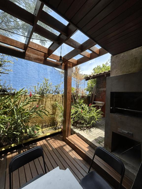 eine Holzterrasse mit Blick auf das Wasser in der Unterkunft Vilarejo Leme in São Sebastião