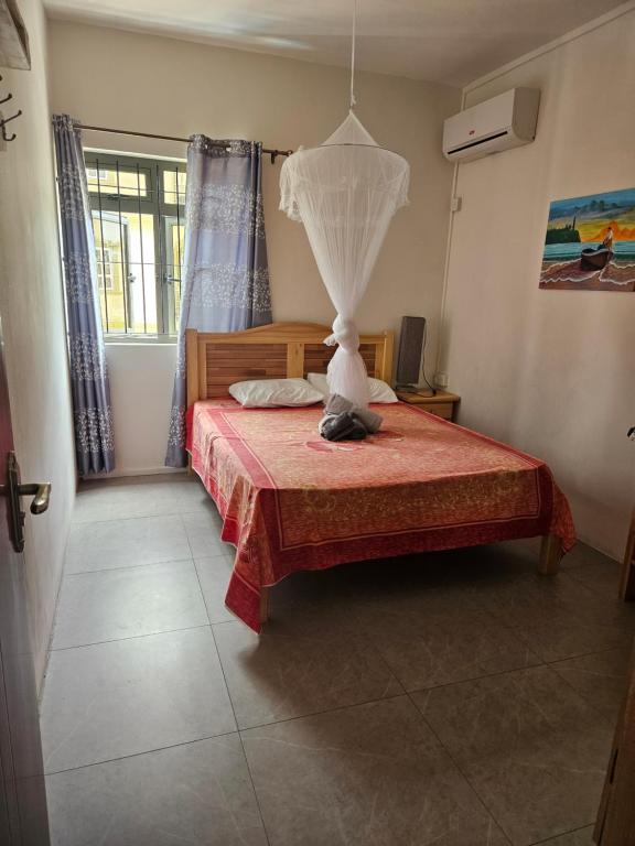 Un dormitorio con una cama con una lámpara encima. en Residence Les Manguiers Fully equipped, en Flic en Flac