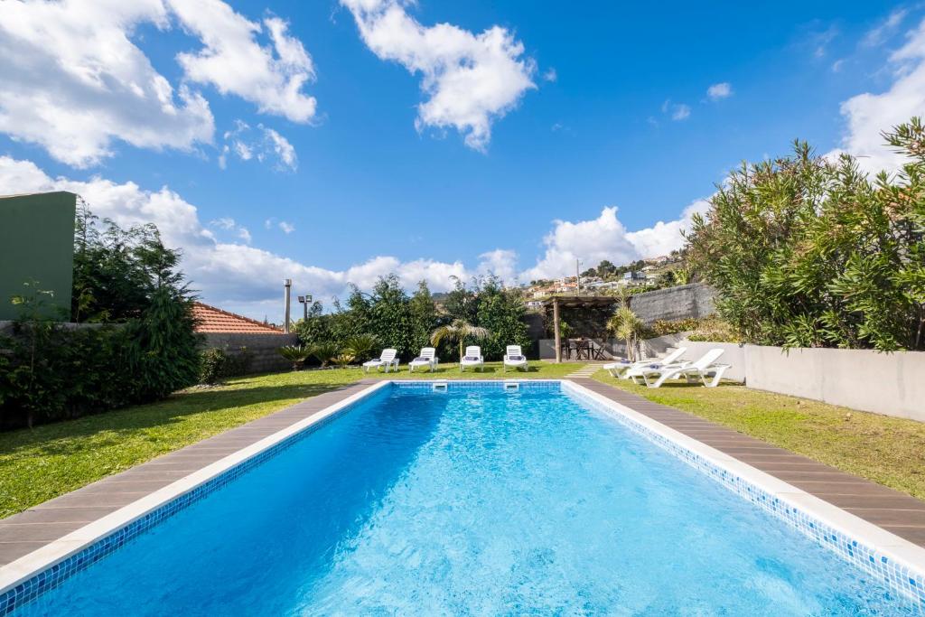 een zwembad in de achtertuin van een villa bij De Casa Villa by GALMI in Estreito da Calheta