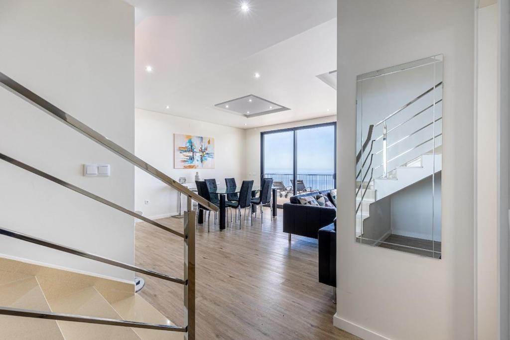 ein Esszimmer und ein Wohnzimmer mit einem Esstisch in der Unterkunft Ocean and Palms in Arco da Calheta