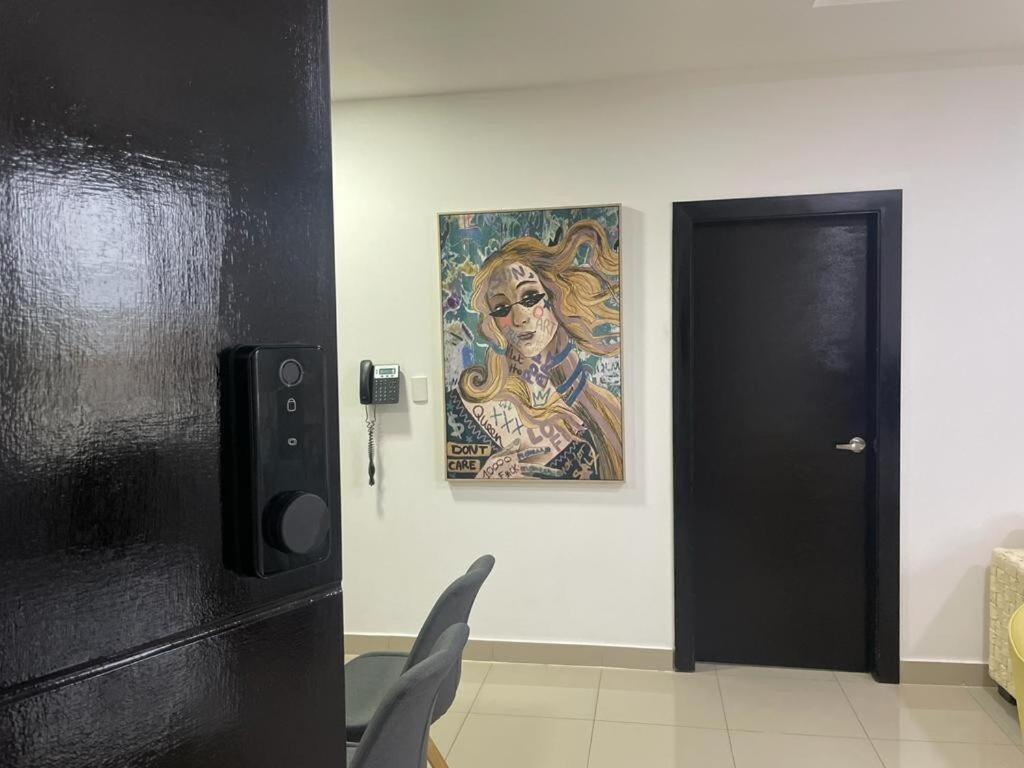 a painting on a wall next to a black door at Lindo y Moderno Departamento, Parqueo in SamborondÃ³n