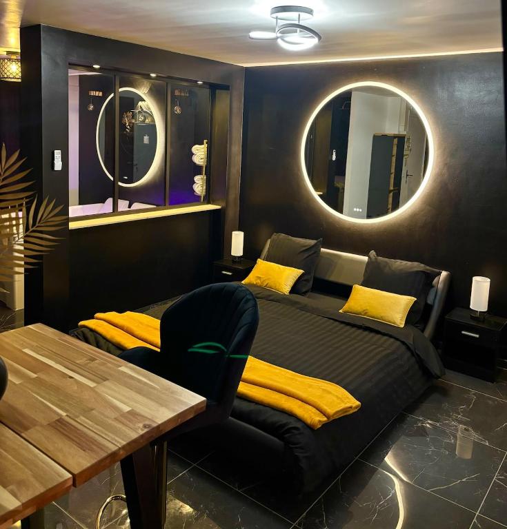 - une chambre avec un lit, une table et des miroirs dans l'établissement Appartement Toulon Jacuzzi Terrasse, à Toulon