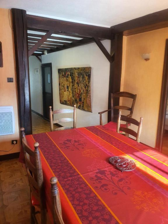 une salle à manger avec une table avec une nappe rouge dans l'établissement Lourdes grand appartement de caractère, à Lourdes