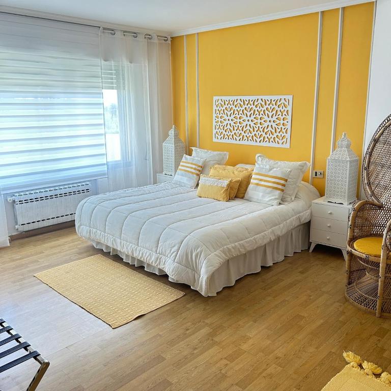 a bedroom with a large bed with yellow walls at Retiro verde en Madrid in Quintana