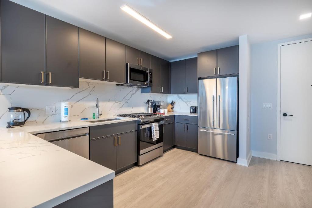 una cucina con elettrodomestici in acciaio inossidabile e armadi marroni di Modern Apt with Indoor Pool a New Rochelle