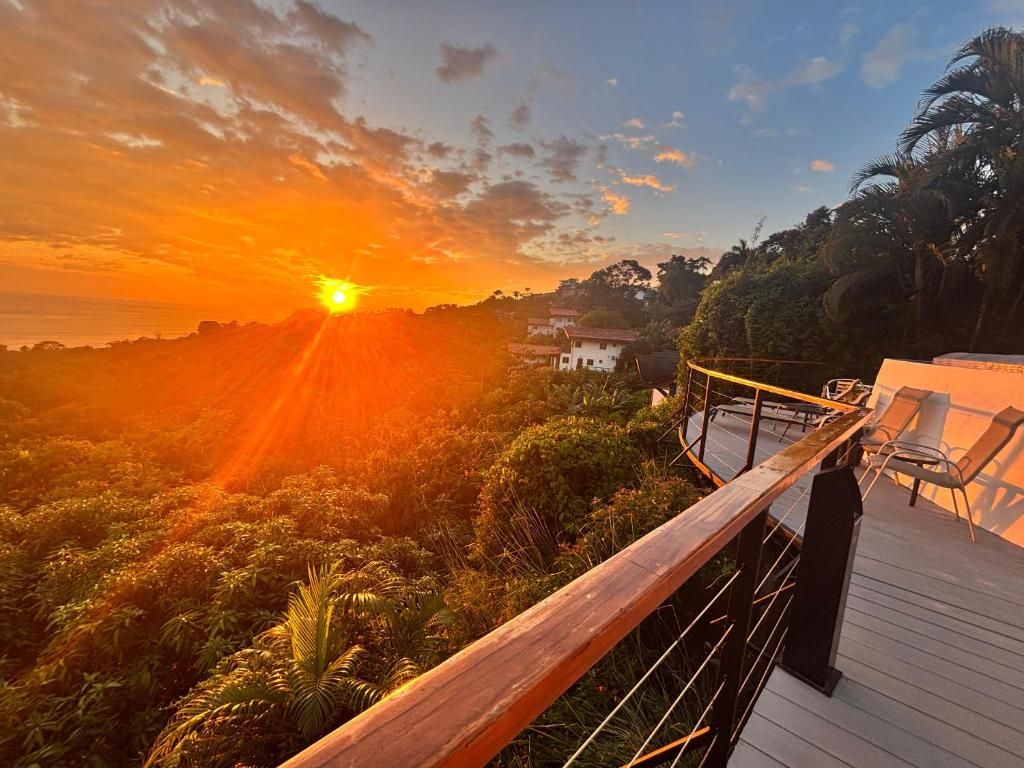 a sunset from the deck of a house at Villa Roca Boutique Resort & Suites - ADULT ONLY in Manuel Antonio