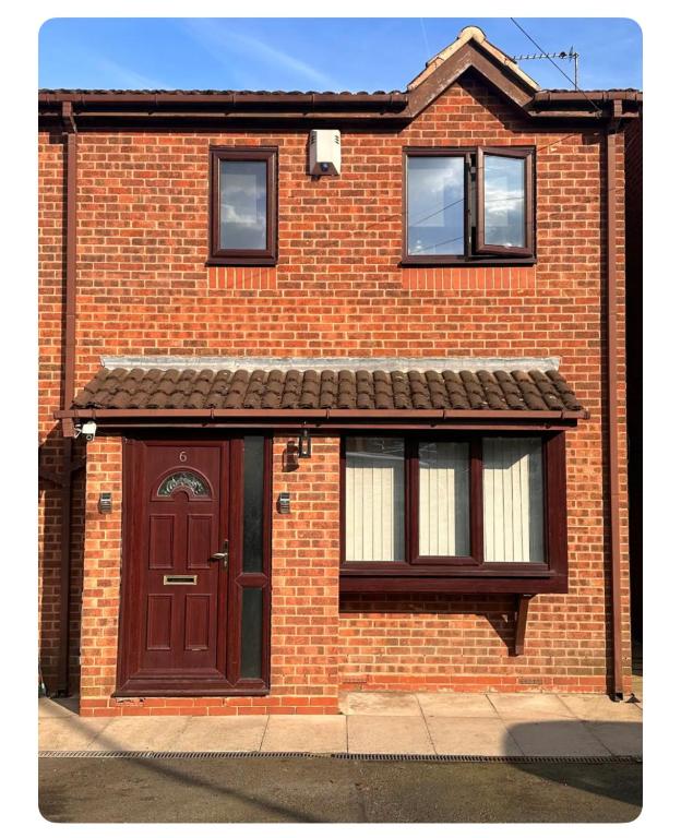a brick house with a brown door and windows at Triple Room near Train Station in Birmingham