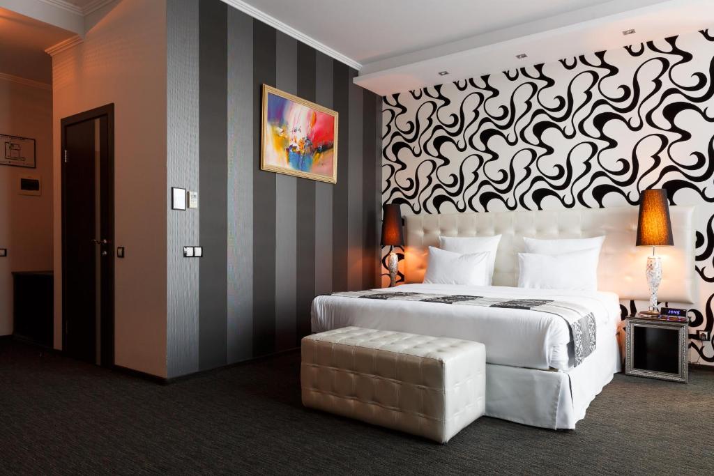 a bedroom with a large white bed and a striped wall at Merotell in Krasnodar