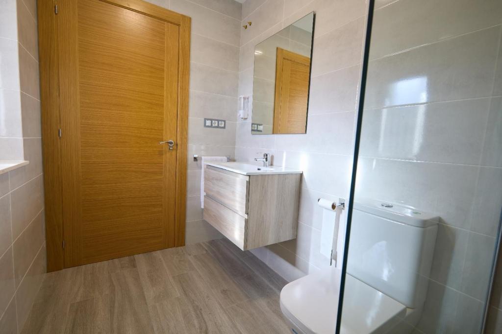 a bathroom with a toilet and a sink and a mirror at Casa Melina in Villapedre