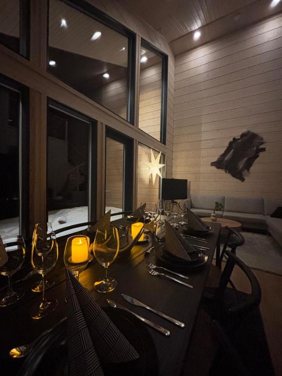 a dining room with a table with wine glasses at Luxury Hideaway Villa Chill Levi by Hilla Villas in Kittilä