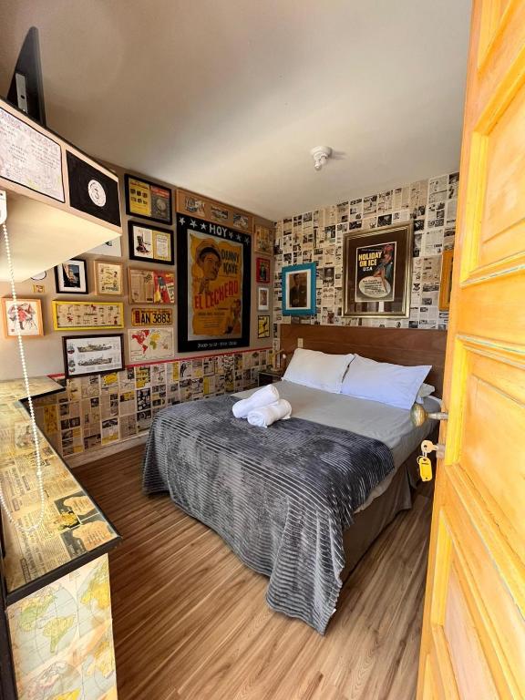 a bedroom with a bed in a room with pictures at La Nueva Posadita in Colonia del Sacramento