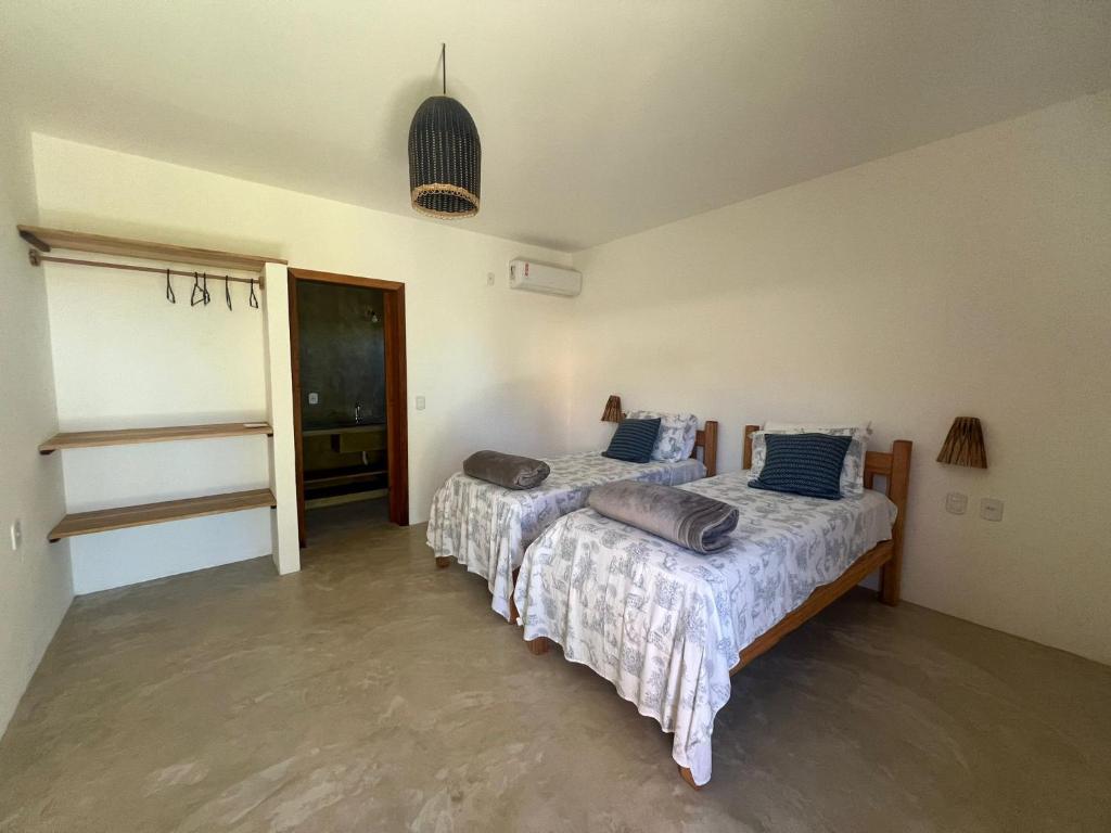 a bedroom with two beds and a hallway with a window at Villa Savoia Corumbau in Corumbau