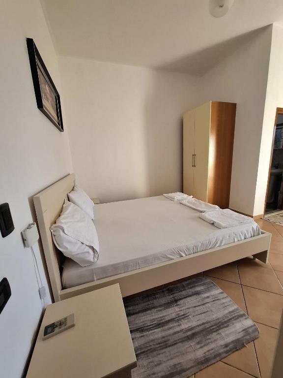 a small room with a bed and a cabinet at Hotel Sirena in Vlorë