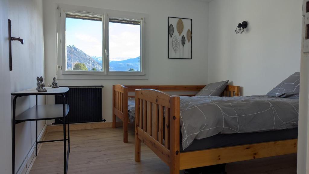 une chambre avec un lit et une grande fen&ecirc;tre dans l'&eacute;tablissement Une belle Escapade &agrave; Lourdes, &agrave; Lourdes