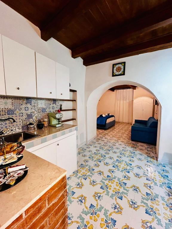 a kitchen with a tile floor and a kitchen with a couch at Dimora San Pietro a Corte in Salerno