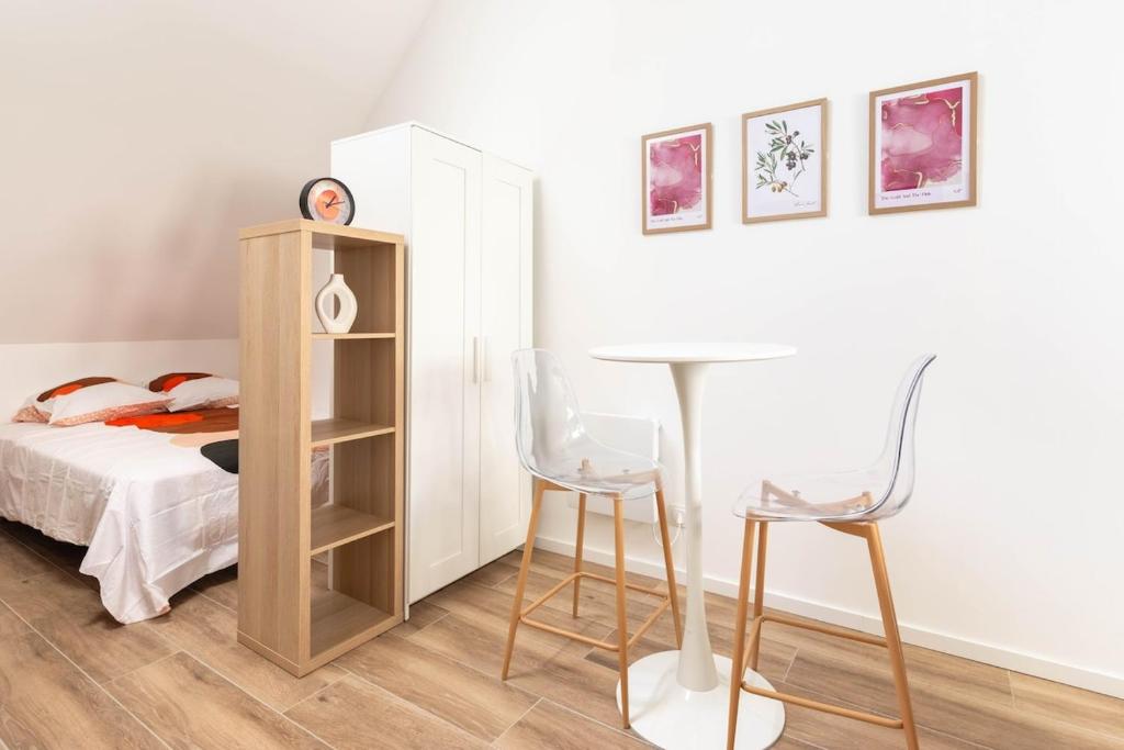 een slaapkamer met een bed, een bureau en stoelen bij Élégant cocon au cœur de Montargis in Montargis