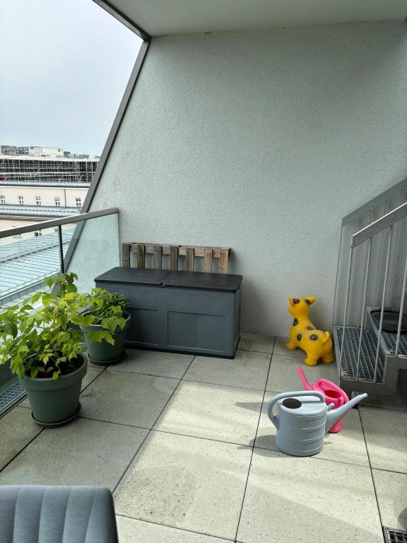 d'une terrasse avec un banc et des plantes sur un balcon. dans l'établissement Wunderschönes Zimmer in einem großen Appartement neben dem Brandenburger Tor und vom Adlon Hotel, à Berlin