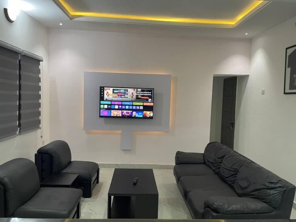 a living room with a couch and a tv on a wall at Plot9 Road9 NTA road in Port Harcourt