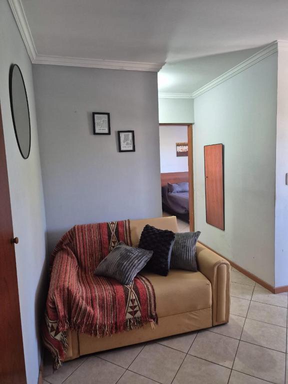 a living room with a couch with pillows on it at LUMINOSO Y COMPLETO DEPARTAMENTO CENTRO Villa Carlos Paz in Villa Carlos Paz