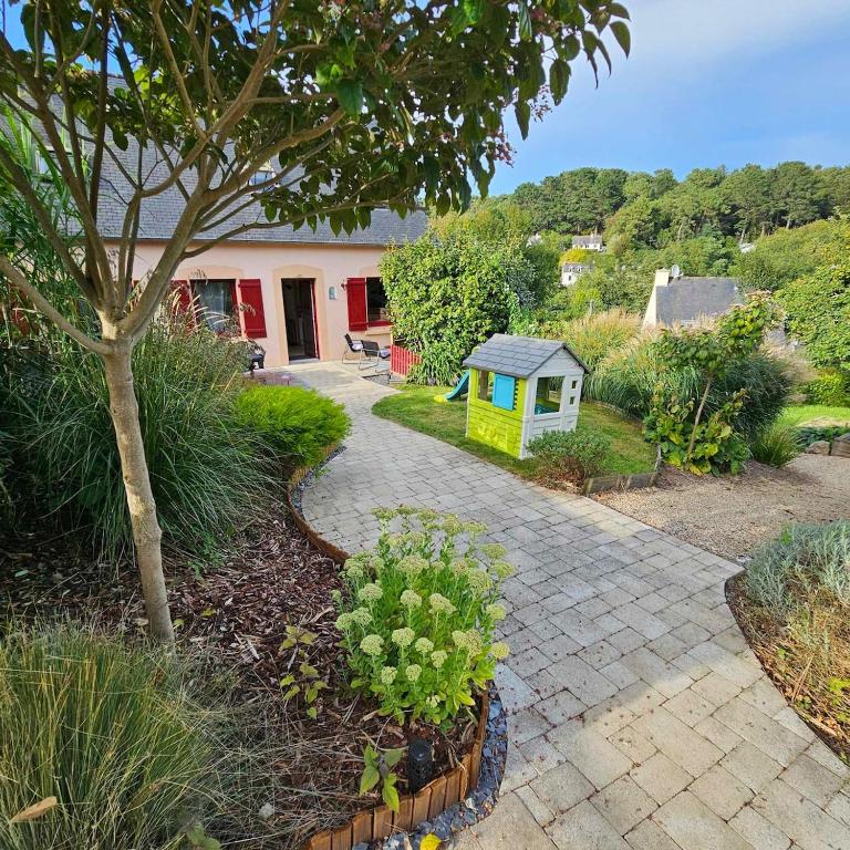 un jardin avec un arbre et une petite maison dans l'établissement HON TI MOR notre Maison de la mer, à Saint-Michel-en-Grève
