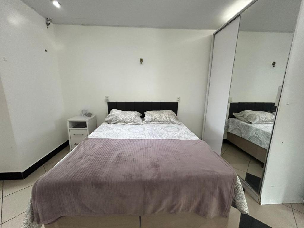 a bedroom with a large bed and a mirror at Apartamento - Ed Sacy - COP 30 in Belém