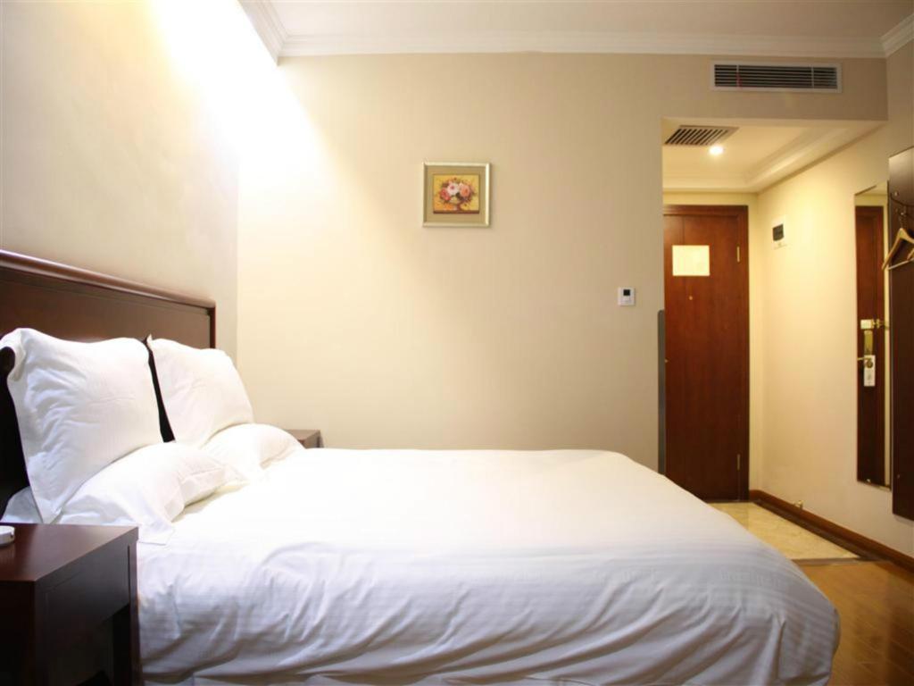 a bedroom with a large white bed in a room at GreenTree Inn Beijing East Yizhuang District Second Kechuang Street Express Hotel in Beijing