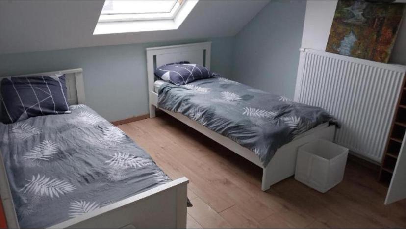 a bedroom with two beds and a skylight at Chambre 2 lit séparé 3eme etage in Brussels