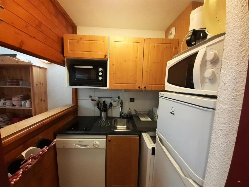 une petite cuisine avec une cuisinière et un micro-ondes dans l'établissement Résidence Chaviere - Studio pour 4 Personnes MAE-4581, à Modane