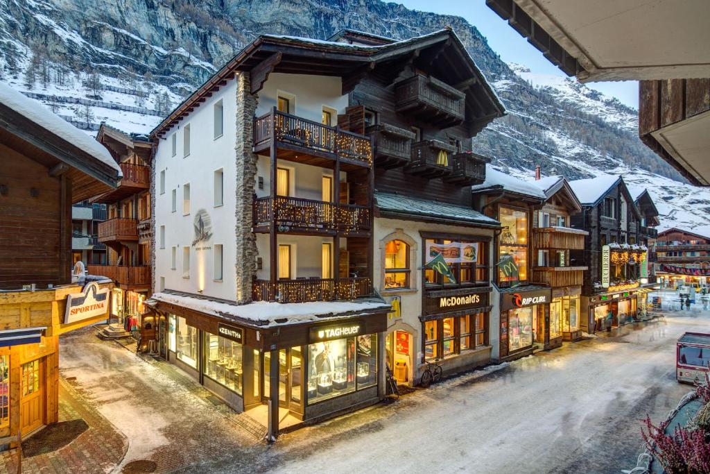 a town in the mountains with snow on the ground at Alpine Lodge in Zermatt