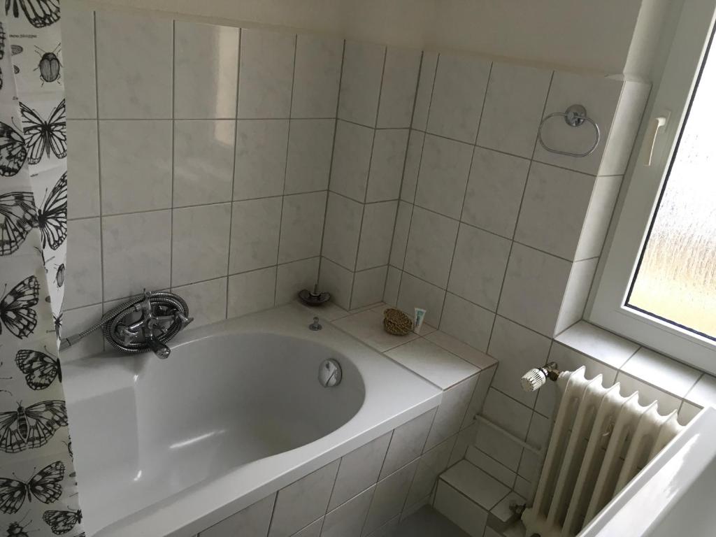 eine weiße Badewanne im Bad mit Fenster in der Unterkunft Lindas Diekblick, 2 Schlafzimmer, EG mit Terrasse in Elsfleth