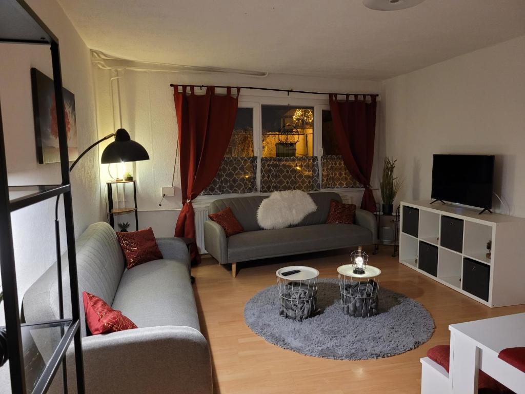 Una sala de estar con un sofá y un televisor. en Ferienwohnung Langenstein, en Langenstein